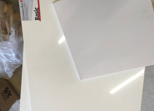 Mehrere weiße Keilrahmen unterschiedlicher Größe liegen auf einem Boden, im Hintergrund ist eine Verpackung mit der Aufschrift 'Gerflor Basic' zu sehen.